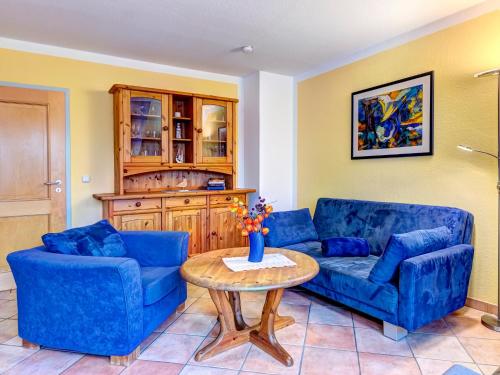 a living room with two blue couches and a table at Haus Sonnenschein FeWo Seekiste in Trassenheide