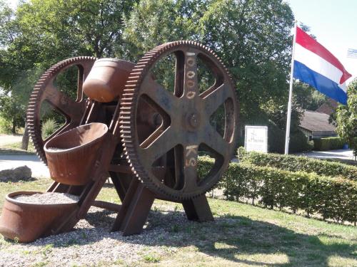 a statue of a wheel with pots and pans at B&B Appartementen Engelenhof in Stevensweert