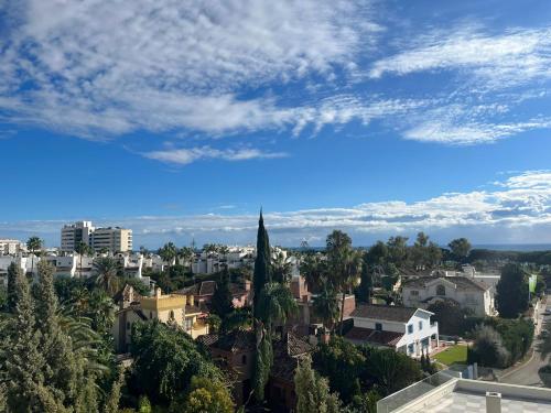 a view of a city with a blue sky at Guadalpin Suites in Marbella