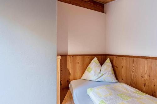 a bedroom with a bed with a wooden headboard at Guntschöllerhof Völseggspitze in Fiè