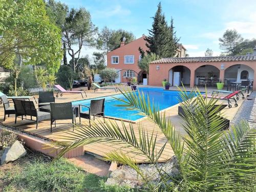 a swimming pool with chairs and a house at VILLA avec piscine - 4 chambres - parking - calme in Les Arcs sur Argens