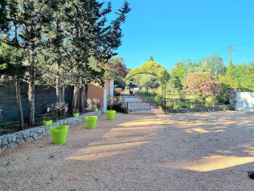 a walkway with green pots in a garden at VILLA avec piscine - 4 chambres - parking - calme in Les Arcs sur Argens