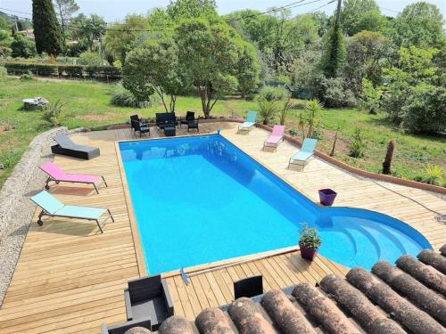 a large swimming pool with a wooden deck at VILLA avec piscine - 4 chambres - parking - calme in Les Arcs sur Argens