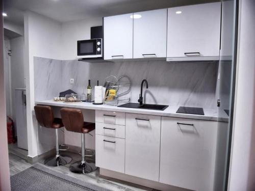 a kitchen with white cabinets and a sink at VitaminSea - Lovran in Lovran