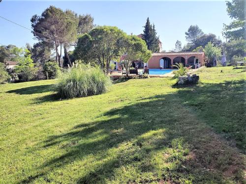 a field of grass with a house and a swimming pool at VILLA avec piscine - 4 chambres - parking - calme in Les Arcs sur Argens