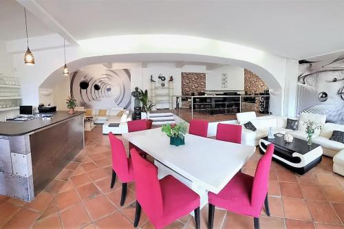 a living room with a white table and pink chairs at VILLA avec piscine - 4 chambres - parking - calme in Les Arcs sur Argens