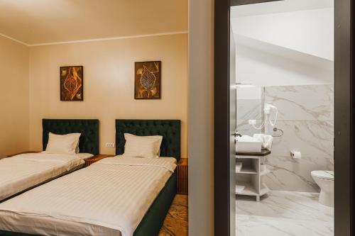 TecuciにあるMotel Andraのバスルーム付きの客室内のベッド2台