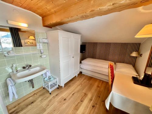 a bathroom with a sink and a bed in a room at Haus Schrofenstein in Lech am Arlberg
