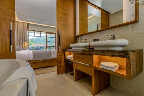 a bathroom with two sinks and a large mirror at Savoy Seychelles Resort & Spa in Beau Vallon