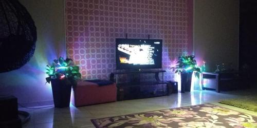 een woonkamer met een tv en wat groene verlichting bij اطلاله مباشره عالنيل in Kafr Abū Dabbūs
