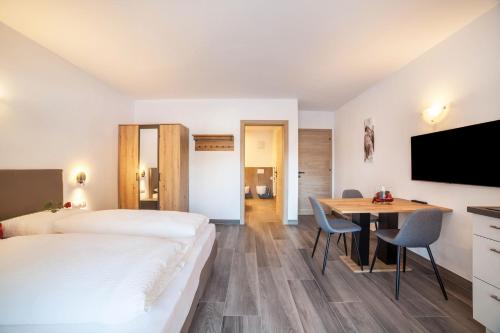 um quarto de hotel com uma cama, uma secretária e uma mesa em Ferienwohnung Berger em Avelengo