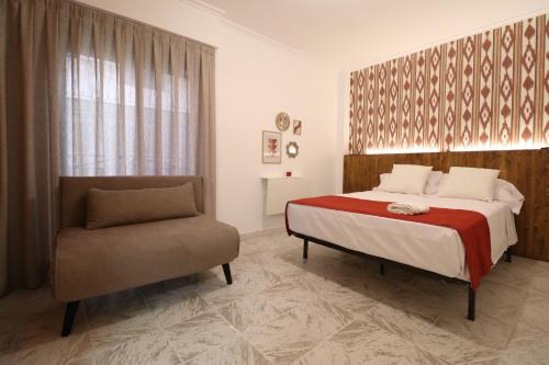 een slaapkamer met een bed en een stoel bij 102 I Posada del Mar I Encantador hostel en la playa de Gandia in Los Mártires