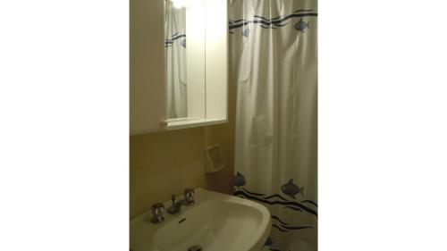 a bathroom with a sink and a shower curtain at Il Quadrifoglio 4 in Procchio