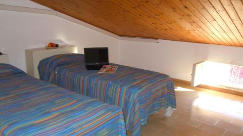 1 dormitorio con 2 camas y un ordenador portátil en una mesa en Il Quadrifoglio 4 en Procchio