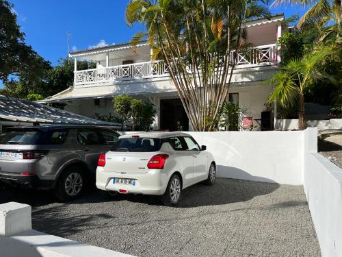 two cars parked in front of a house at La plage de Petit-Havre in Le Gosier