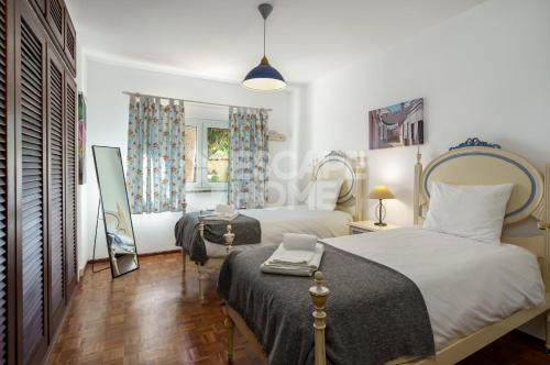a bedroom with two beds and a mirror at Quinta do Vale Formoso in Armação de Pêra