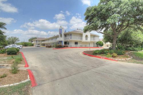 a road in front of a large white building at Motel 6 San Antonio, Tx Six Flags Fiesta TX - La Cantera Area in San Antonio