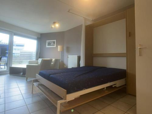 a bedroom with a bed and a living room at Meidoornstraat 2 parterre in Cadzand