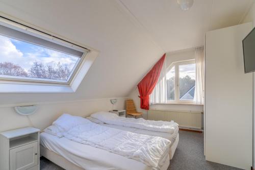 2 camas en una habitación con 2 ventanas en Villapark Kamperfoelie 77, en De Koog