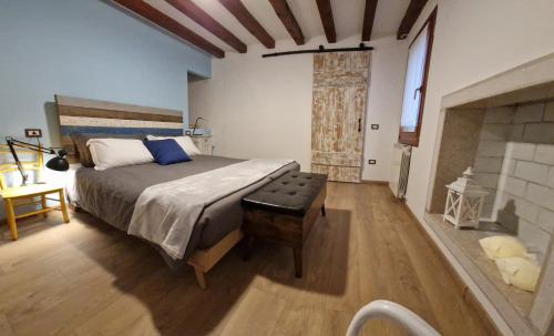 een slaapkamer met een groot bed en een open haard bij Cà Wanda in Chioggia
