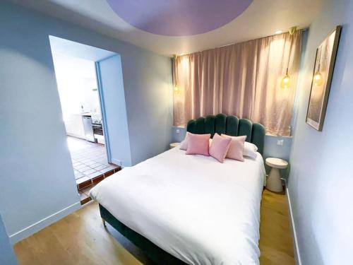 sypialnia z dużym białym łóżkiem z różowymi poduszkami w obiekcie Appartement Aquaroom RDC - Plage 50m - Rue gratuite w Saint-Malo