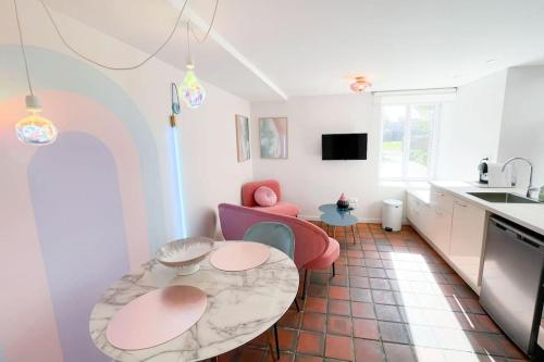 une cuisine avec une table et des chaises dans une pièce dans l'établissement Appartement Aquaroom RDC - Plage 50m - Rue gratuite, à Saint-Malo