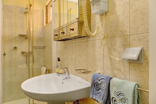 a bathroom with a sink and a mirror at Palheiro Residence Familiar 2 in Funchal