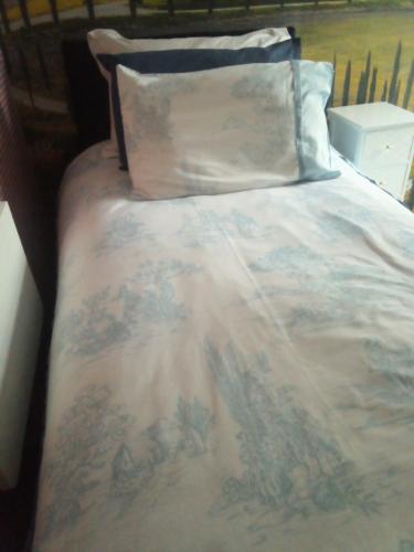 Homestay Cardiff في كارديف: سرير مع بطانيه عليها صليب