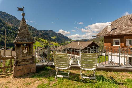 a group of chairs sitting in front of a house at Residence Prapoz in Ortisei