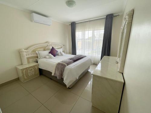 a bedroom with a white bed and a window at Estee House in Newcastle