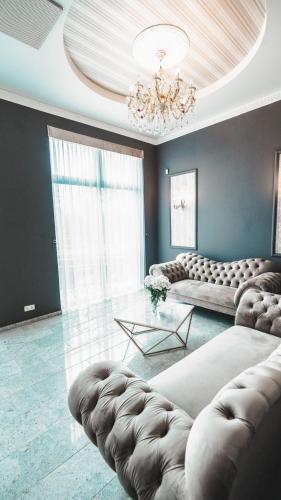 a living room with a couch and a chandelier at Hotel Santana in Białystok