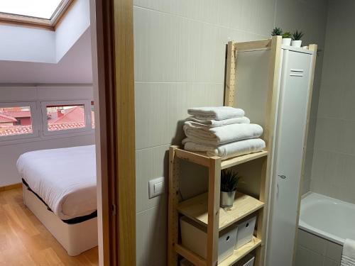 Habitación con cama, espejo y toallas. en Vivienda turística Los Tejados en Soria