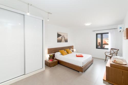 1 dormitorio con 1 cama y pared de cristal en Villa Diamond by Villa Plus, en La Oliva