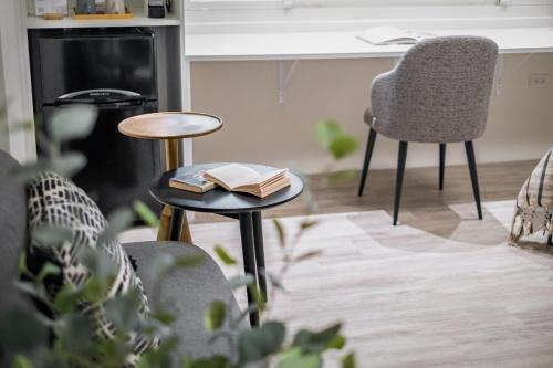 a living room with two chairs and a table with books at Lin Suites by Olala Homes in Taipei