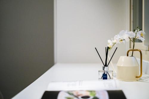 a table with a vase of flowers and a candle at Lin Suites by Olala Homes in Taipei