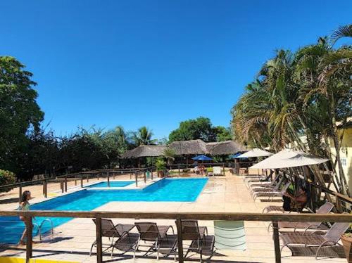 a resort swimming pool with chairs and umbrellas at Hotel Fazenda Cachoeiras Serra da Bodoquena in Bodoquena