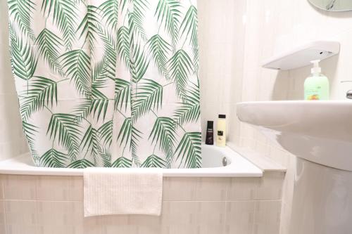 baño con cortina de ducha verde y blanca en 102 I Posada del Mar I Encantador hostel en la playa de Gandia, en Los Mártires