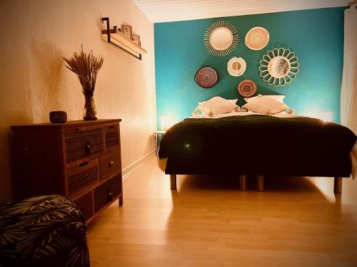 sypialnia z łóżkiem i zieloną ścianą w obiekcie Gîte Aux Quatre Vents avec Terrasse w mieście Rouffach