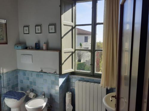 a bathroom with a sink and a toilet and a window at Fattoria Michela in Matraia