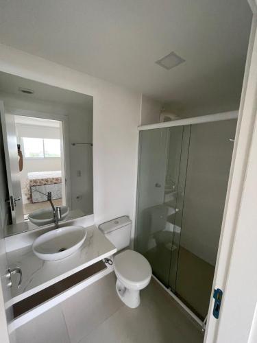 a bathroom with a toilet and a sink and a shower at Apartamento 2 quartos c/ Piscina 3 Ar-condicionado in Torres