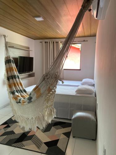 a bedroom with a bed with a hammock in it at ChaleVille - Chalé 4902 in Luis Correia
