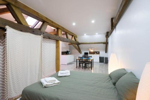 een slaapkamer met een groen bed met 2 handdoeken erop bij The Backstage in La-Roche-en-Ardenne