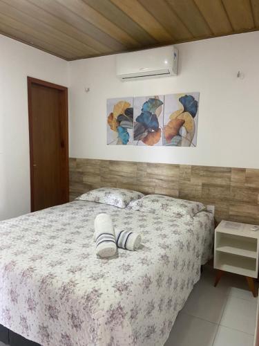 a bedroom with a bed with two slippers on it at ChaleVille - Chalé 4902 in Luis Correia