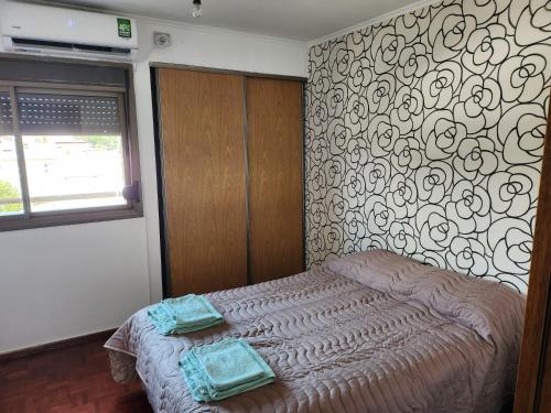 a bedroom with a bed with two towels on it at Departamento Centro in San Fernando del Valle de Catamarca
