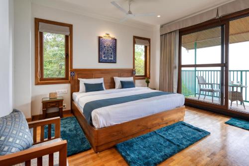 1 dormitorio con 1 cama y balcón en StayVista at Paradise Valley View with Terrace Access en Munnar