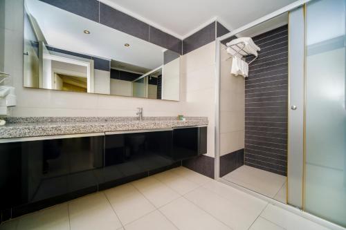een badkamer met een wastafel en een spiegel bij Delfino Apart Hotel in Alanya