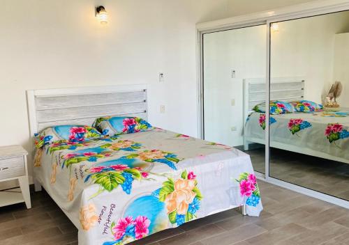 een slaapkamer met 2 bedden en een grote spiegel bij Villa Daniela in Punta Rucia