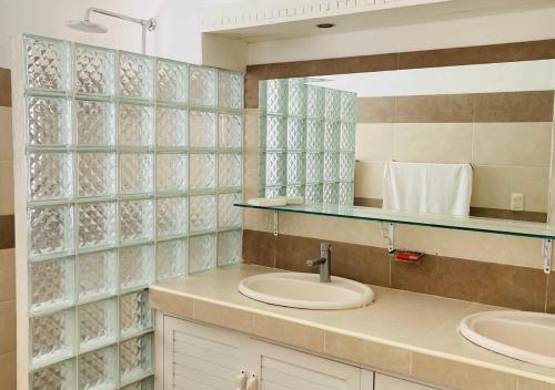 a bathroom with two sinks and a mirror at Villa Daniela in Punta Rucia