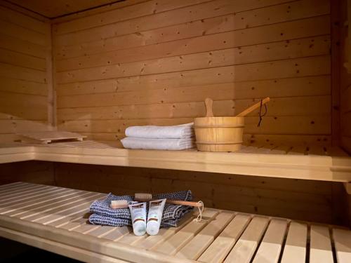 - un sauna avec des serviettes et des chaussures sur une étagère dans l'établissement Boerderij Appartementen Ûnder de Wol - Súdwest Fryslân, à Oudega