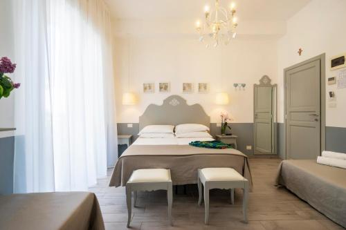 1 dormitorio con 1 cama grande y 2 sillas blancas en Aparthotel Daniel, en Bellaria-Igea Marina